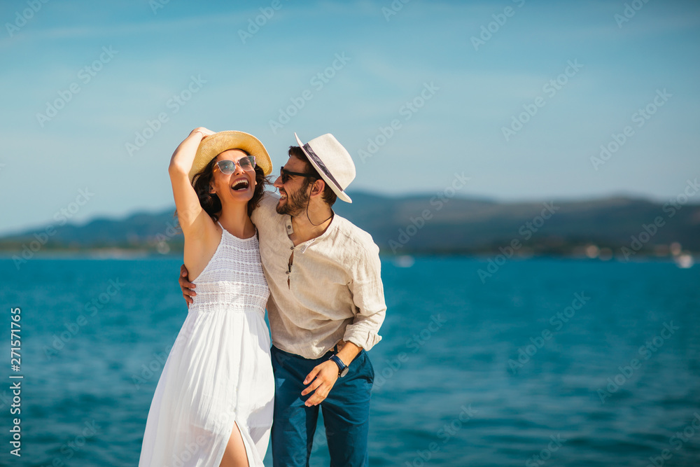 Young beautiful tourist couple enjoying summer holiday on the seaside Young beautiful tourist couple enjoying summer holiday on the seaside