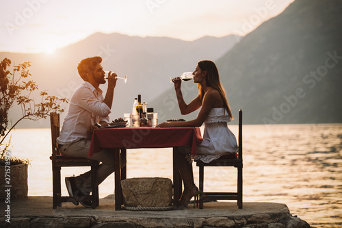 Fototapeta Couple is having a private event dinner on a tropical beach during sunset time