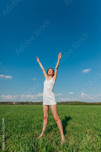  girl reaches out with arms up on green field