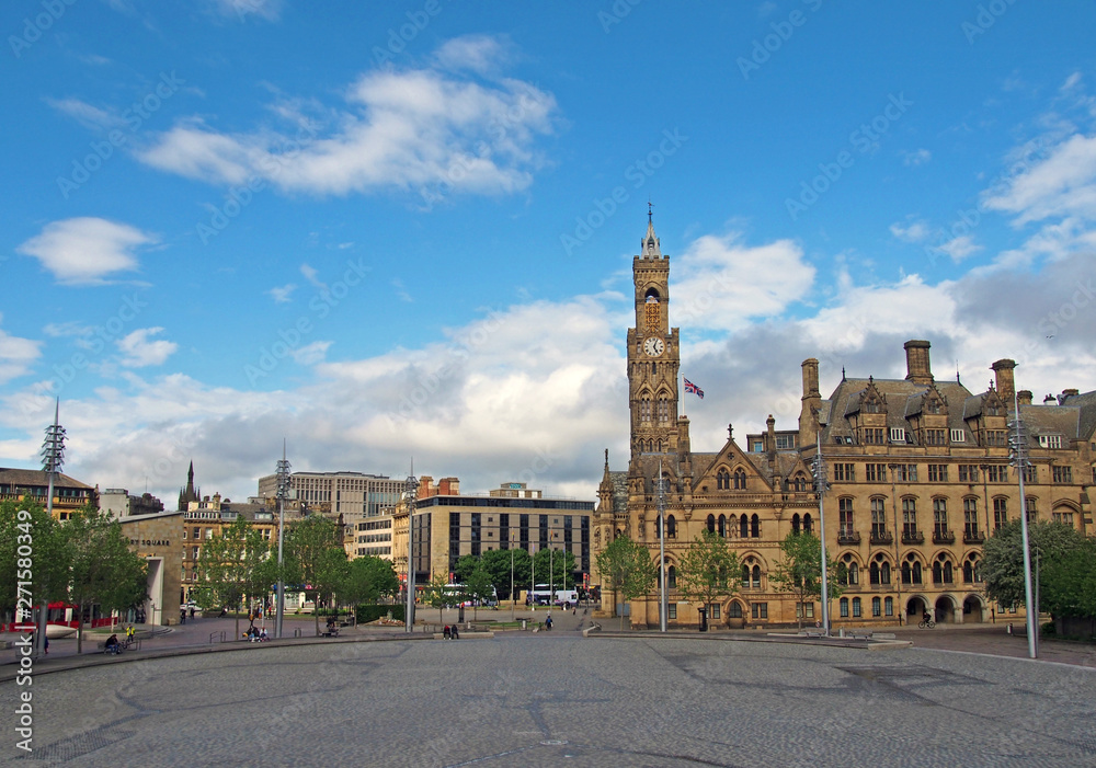 a cityscape view of centenary square and town centre in bradford west yorkshire with people sitting and walking past the city hall and main streets