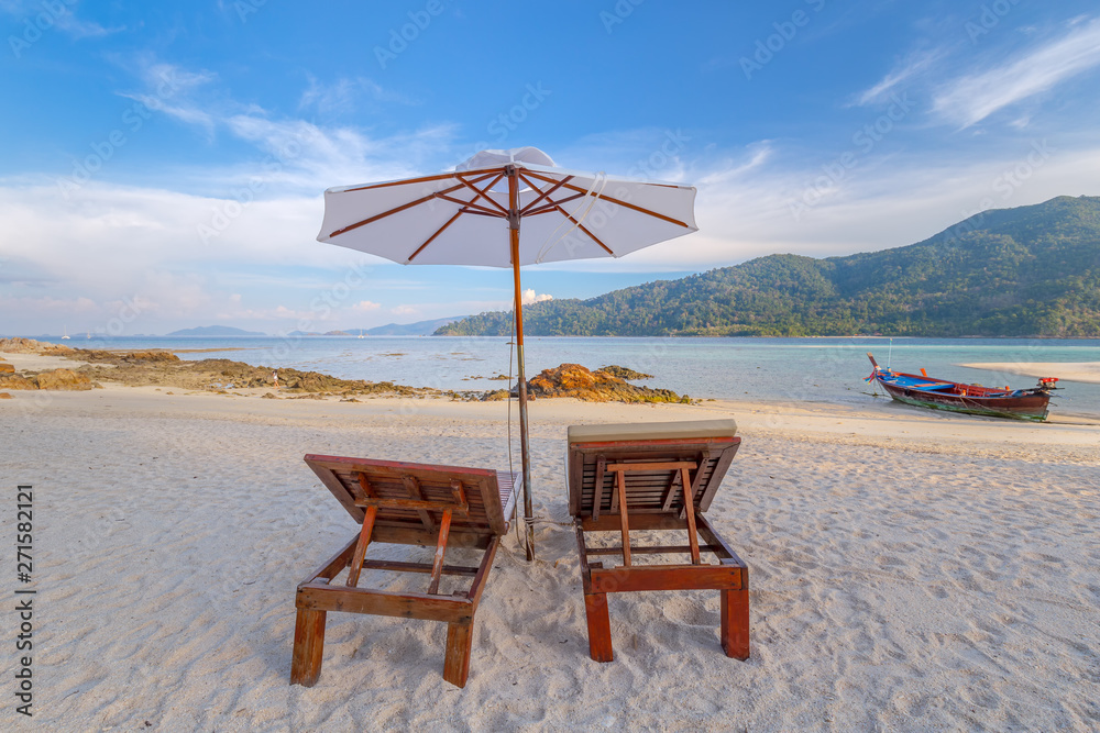 Beach chairs, umbrella and palms on the beautiful beach for holidays and relaxation at Koh Lipe island, Thailand