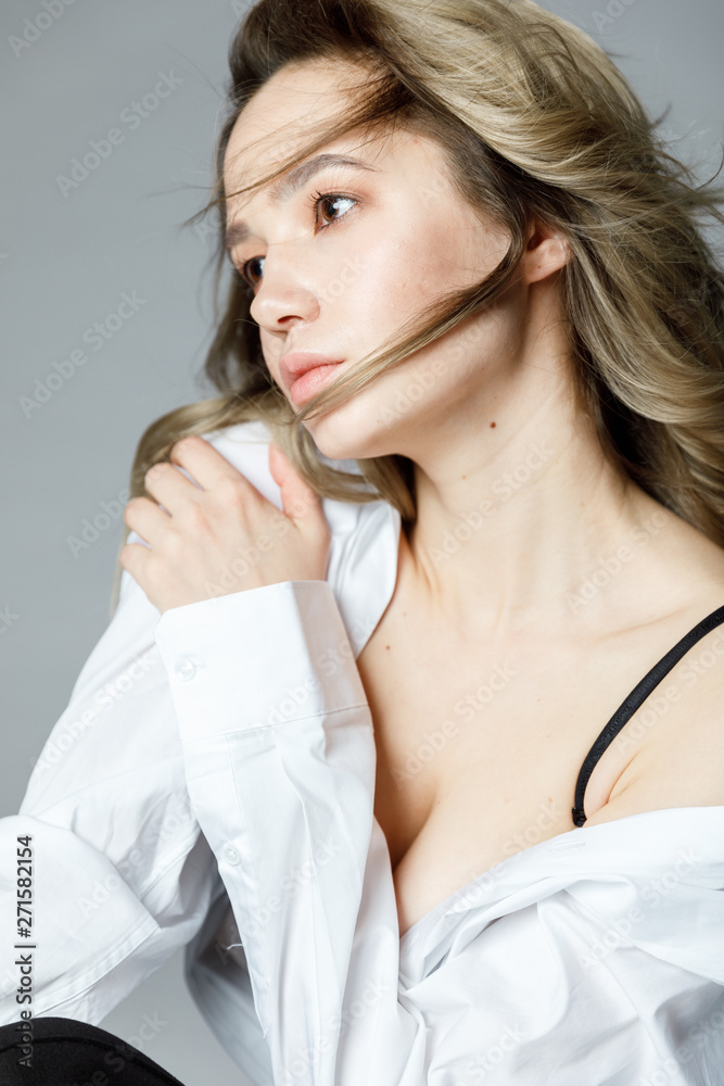 Portrait of a blonde girl in a white blouse and black bra Portrait of a blonde girl in a white blouse and black bra