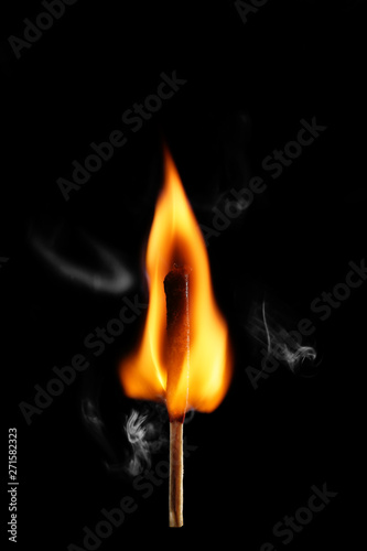 Burning match on dark background