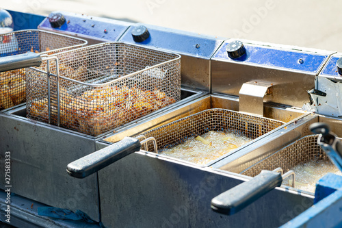 Deep-fried potatoes. French fries fried in boiling oil in a fryer. photo