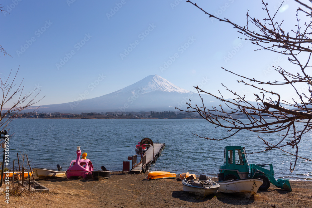 tree branches foreground, small dock on kawaguchiko lake and Fuji mountain tree branches foreground, small dock on kawaguchiko lake and Fuji mountain