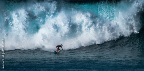 Surfer rides huge wave at the famous Banzai Pipeline surf spot located on the North Shore of Oahu in Hawaii