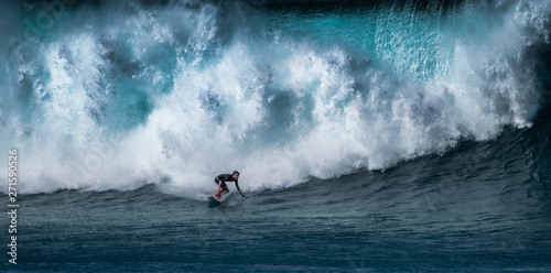 Photography Surfer rides huge wave at the famous Banzai Pipeline surf spot located on the No