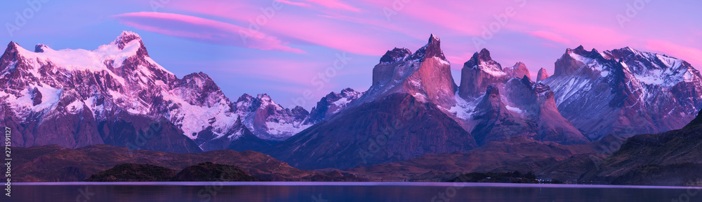 Torres del Paine National Park with snow capped mountains (Cordillera Paine) and calm lake of Pehoe at the sunrise Chile