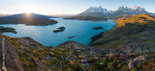 Panorama of Torres del Paine National Park with snow capped mountains (Cordillera Paine) and blue lake of Pehoe as seen from the Mirador Condor during sunset. Chilean Patagonia