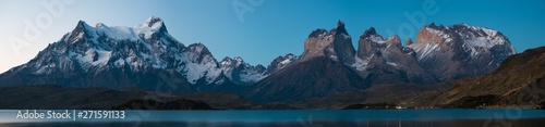 Panorama of Torres del Paine National Park with snow capped mountains (Cordillera Paine) and calm lake of Pehoe at late evening with stars in the sky. Chile
