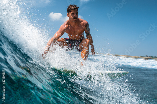 Hispanic surfer rides the ocean wave on the Jailbreaks surf spot in Maldives