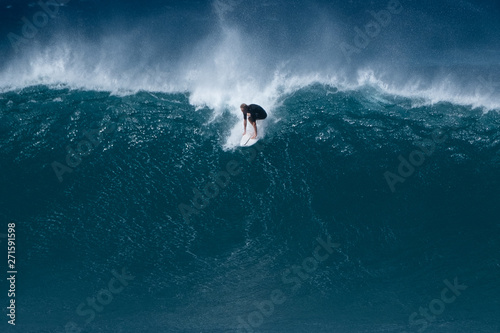 Surfer rides giant wave at the famous Banzai Pipeline surf spot located on the North Shore of Oahu in Hawaii