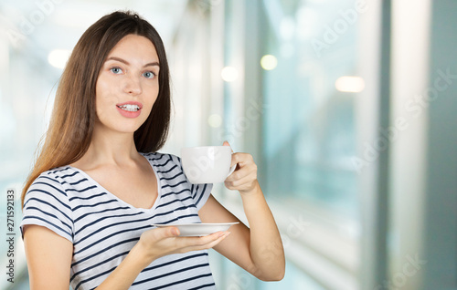 Happy woman enjoying a warm cup of tea or coffee for breakfast