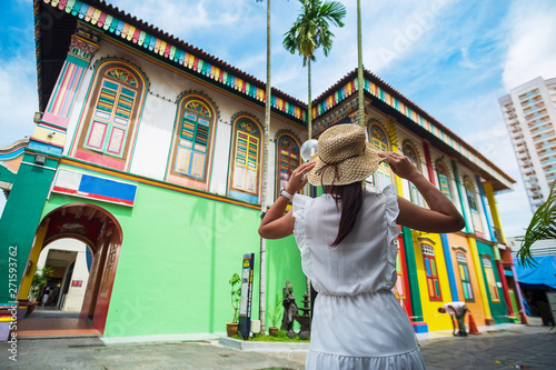 Photography Young woman traveling with hat, Happy traveler looking to colorful building in Little India district, Singapore
