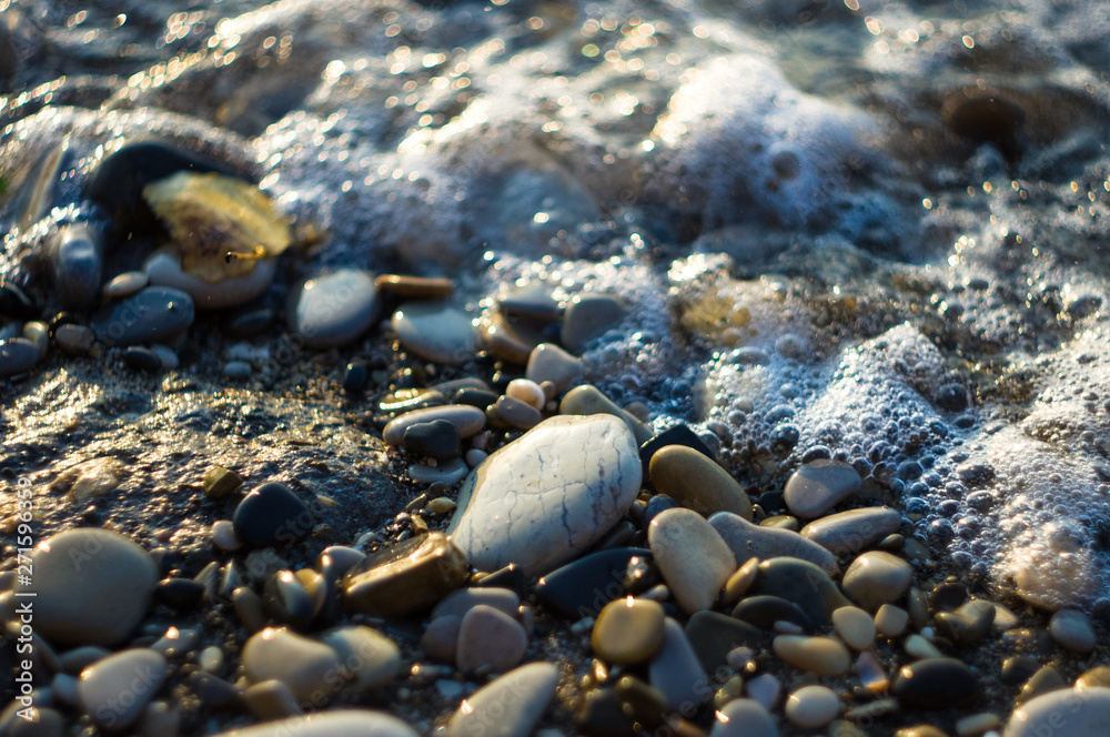 pebble stones on the sea beach, the rolling waves of the sea with foam pebble stones on the sea beach, the rolling waves of the sea with foam