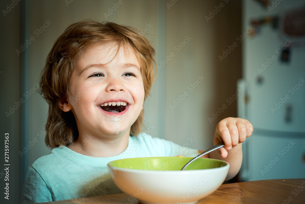 Kid eating. Little boy having breakfast in the kitchen. Smiling happy adorable baby eating fruit mash in the kitchen. Hungry little boy eating. Kid eating. Little boy having breakfast in the kitchen. Smiling happy adorable baby eating fruit mash in the kitchen. Hungry little boy eating.
