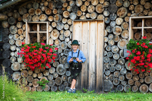 Smiling bavarian boy with flowers on the farm in Germany .Happy little boy wearing a traditional Bavarian clothes photo
