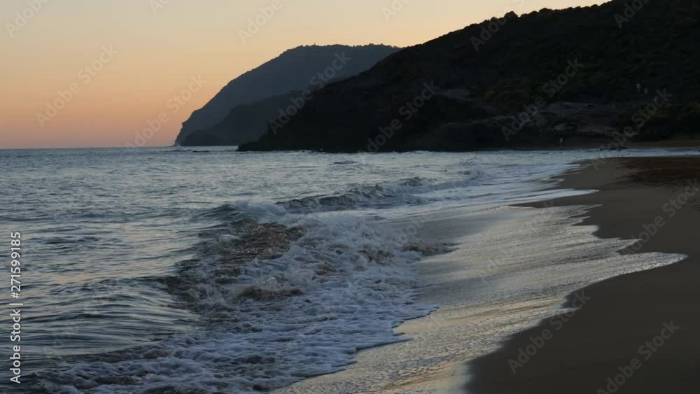The lonely and beautiful Mediterranean beach of Calblanque near the Spanish city of Cartagena in the evening after sunset. The waves are rolling on the beach. The lonely and beautiful Mediterranean beach of Calblanque near the Spanish city of Cartagena in the evening after sunset. The waves are rolling on the beach.