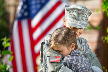 Happy reunion of female mother soldier with family son outdoors