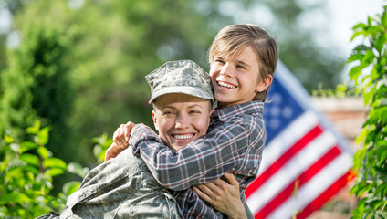 Happy reunion of female mother soldier with family son outdoors