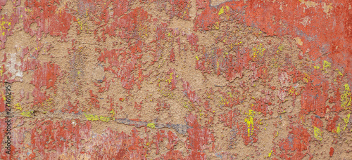 Old cracked weathered shabby red yellow painted plastered peeled wall banner background. © vejaa