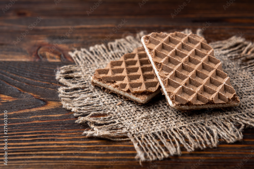 Chocolate waffles with milk filling on dark wooden background. Chocolate waffles with milk filling on dark wooden background.