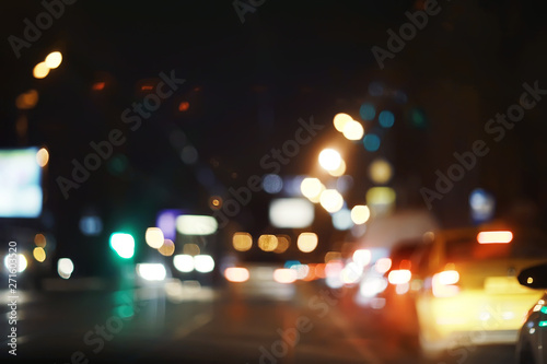 view of car in traffic jam / rear view of the landscape from window in car, road with cars, lights and the legs of the cars night view