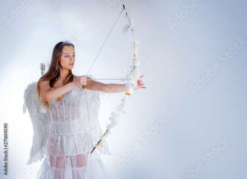 Sweet girl wearing angel costume white dress and feather wings. Cupid in valentine day. Valentines day cupid. Teen angel. Enjoying magic moment. Angel children girl with white wings.