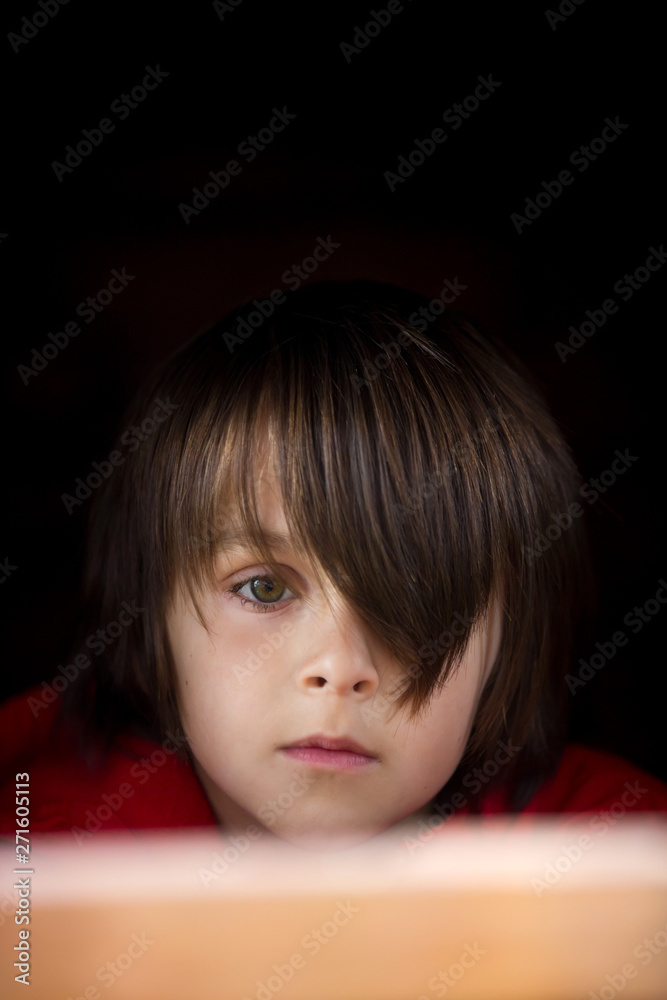 Preteen boy in red sweatshirt, hiding behind a wooden door, looking scared Preteen boy in red sweatshirt, hiding behind a wooden door, looking scared