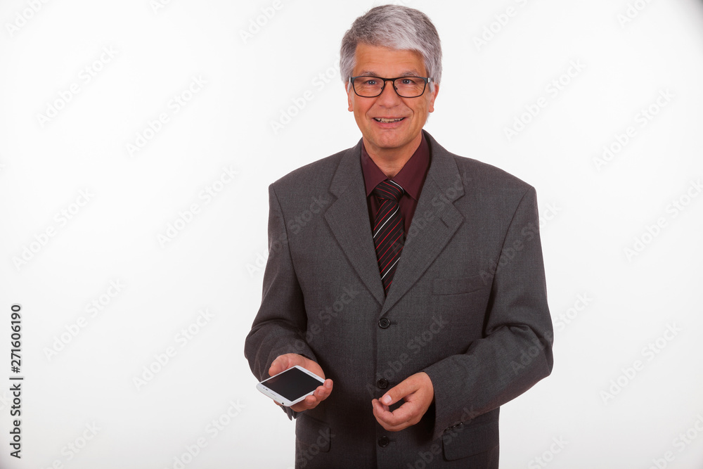 attractive mature European (Caucasian) slim businessman with short grey hair, grey suit, glasses, tie and purple shirt in front of white background, he holds a smartphone and explains something attractive mature European (Caucasian) slim businessman with short grey hair, grey suit, glasses, tie and purple shirt in front of white background, he holds a smartphone and explains something