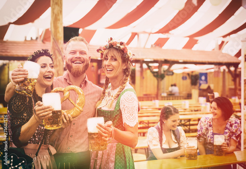 Fotografie Freunde auf dem Oktoberfest im Bierzelt mit Maß Bier
