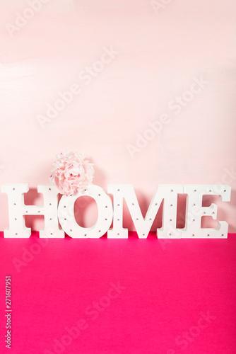 Word HOME from the wooden decorative letters on pink background