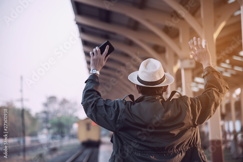 Travel man wait train at platform - people vacation lifestyle activities at train station transportation concept