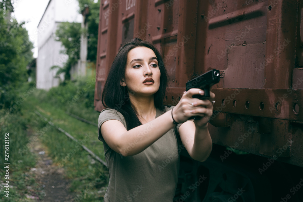 Powerful Woman Holding Gun Action Movie Style. Train adventure. Military girl with . Powerful Woman Holding Gun Action Movie Style. Train adventure. Military girl with .