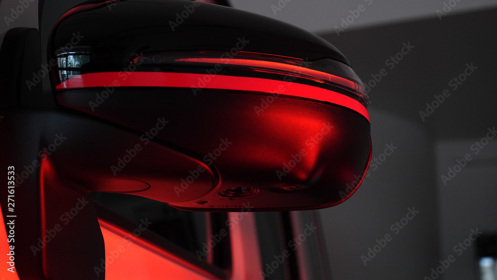 Infrared drying of car body parts after applying putty and paint on a white off-road vehicle in the body repair shop with red lanterns in the working environment. Concept of: Car Ceramic, Slow Motion.