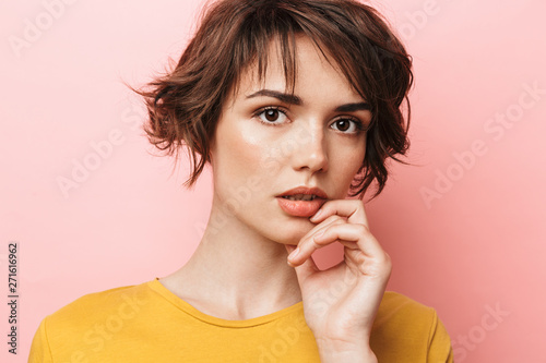 Young beautiful woman posing isolated over pink wall background.