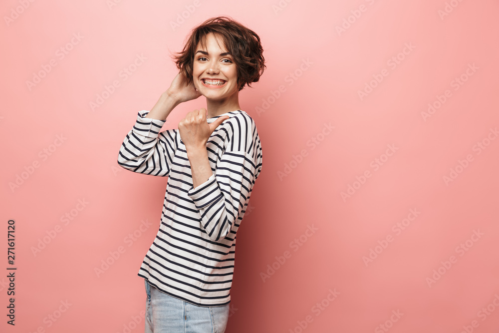 Happy beautiful woman posing isolated over pink wall background pointing. Happy beautiful woman posing isolated over pink wall background pointing.