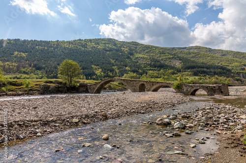 Long old stone bridge over a river