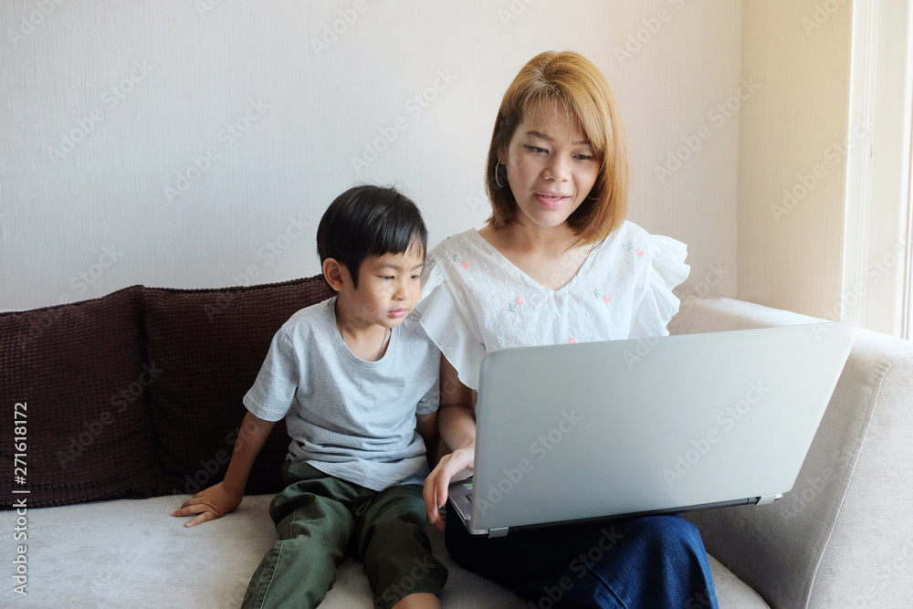 Asian Mother teaching her son for use laptop computer Asian Mother teaching her son for use laptop computer