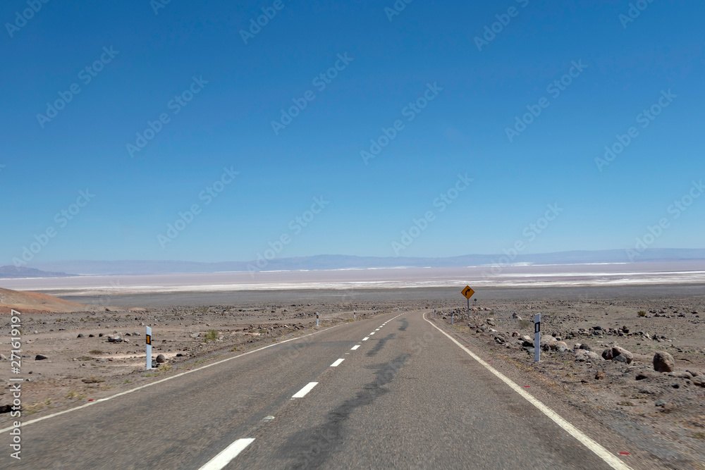 Lonely road in Atacama desert landscape background with copy space for text