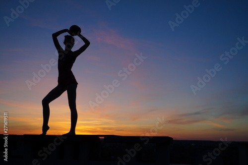 Fototapeta Naklejka Na Ścianę i Meble -  dancer in the dance does the splits in the air against the sunset