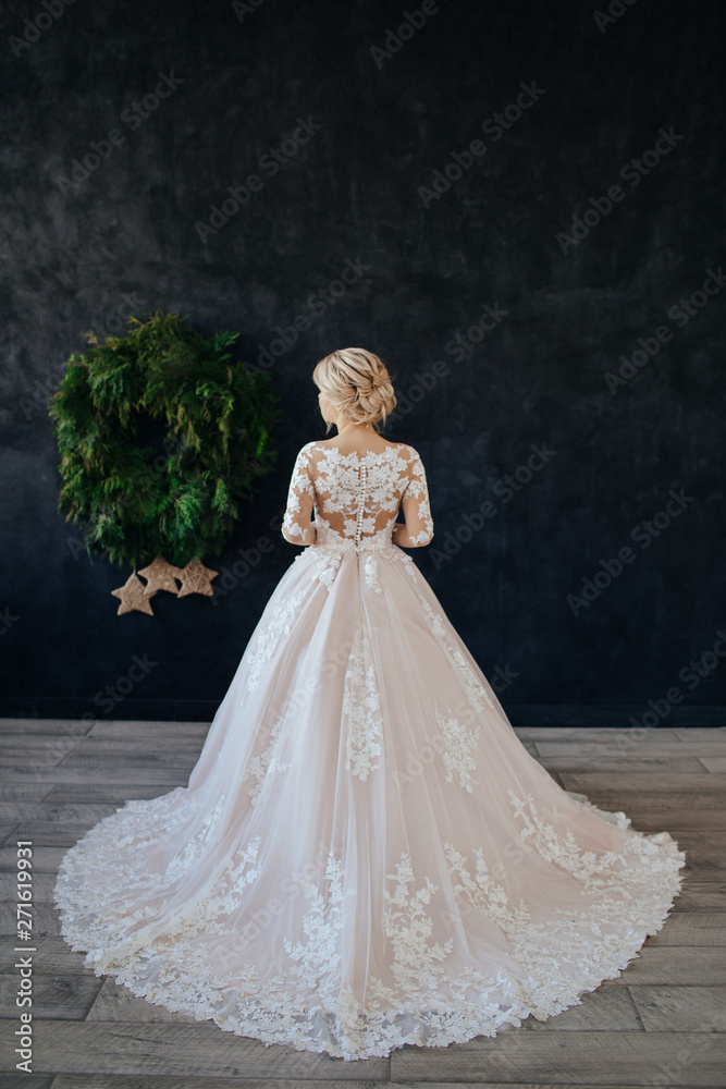 The bride in a magnificent, white, wedding dress with a long train.