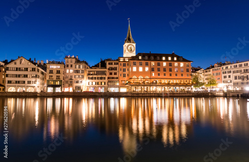 Zurich skyline with St. Peter church along the Limmat river during twilight