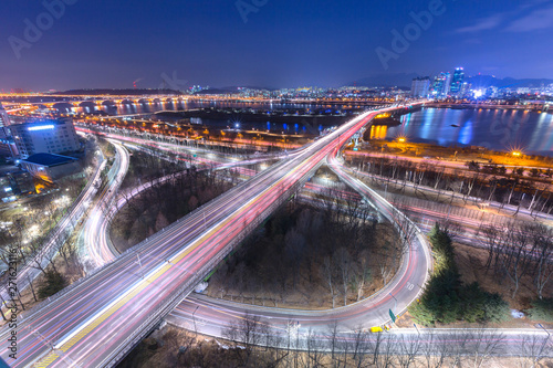 Korea travel, Cars passing in intersection, Han River and bridge at Night in Downtown Seoul, South Korea.