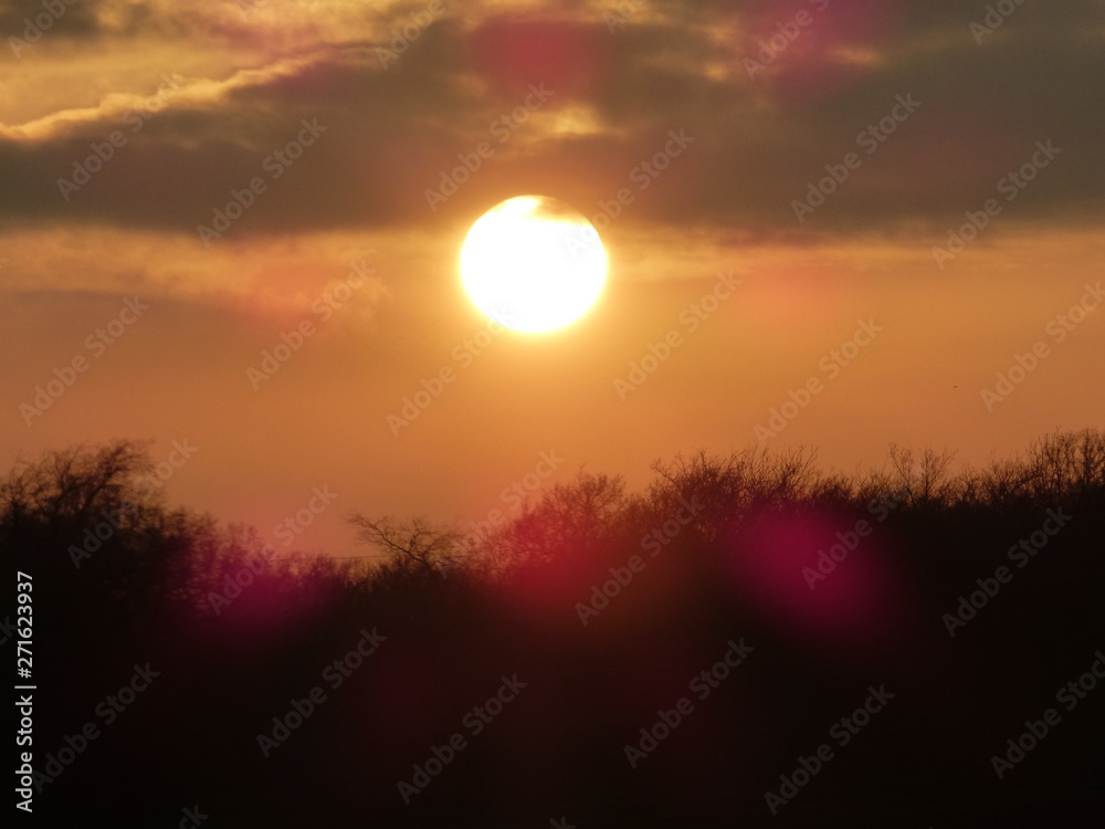 sun dipping below the clouds just before sunset