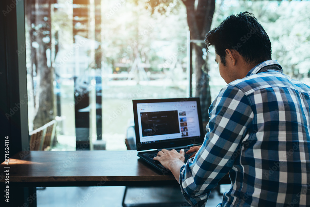 Asian man using laptop with youtube website and smartphone with skype, freelance man. Asian man using laptop with youtube website and smartphone with skype, freelance man.