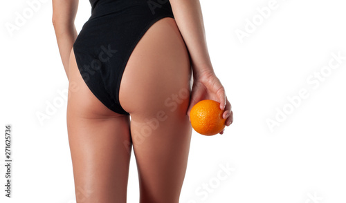 Body care and anti cellulite massage. Perfect female buttocks without cellulite. Beautiful woman's butt in underwear with orange.