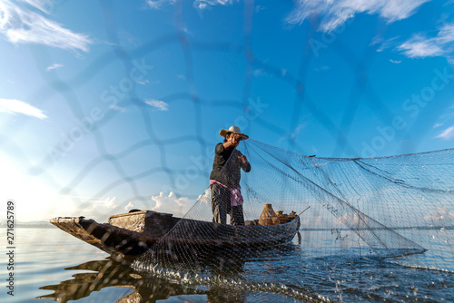 Fisherman action when fishing net on lake in the sunshine morning outdoors on the boat. Agriculture Industry, Thailand