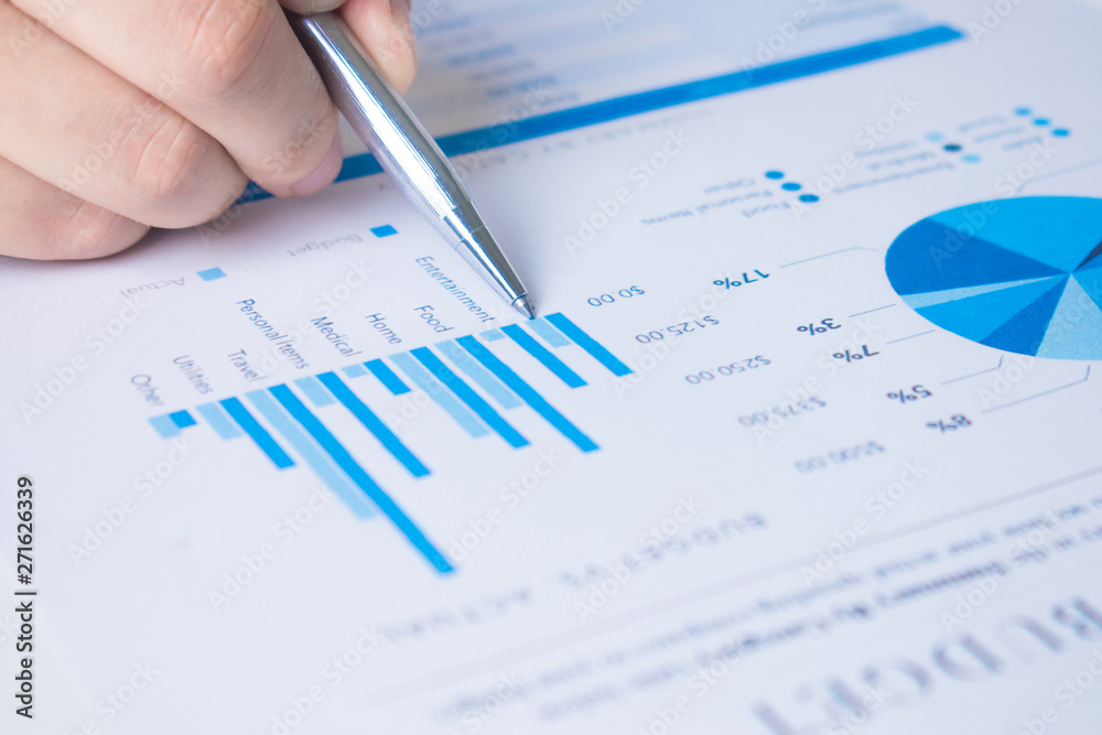 Close up to the hands of business professionals, use the pen to point to the graph and explain some numbers. Close up to the hands of business professionals, use the pen to point to the graph and explain some numbers.