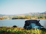 spring season activity concept from camera bag of traveler or photographer man put on floor with lake view in morning time background